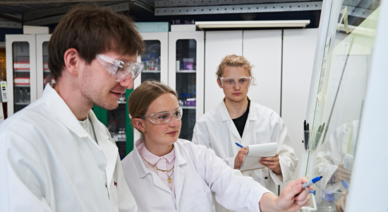 Tre kemistuderende i laboratorie
